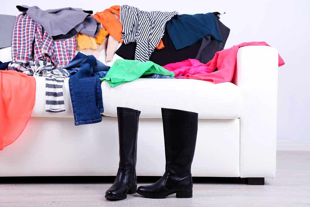clothes on a couch ready to declutter
