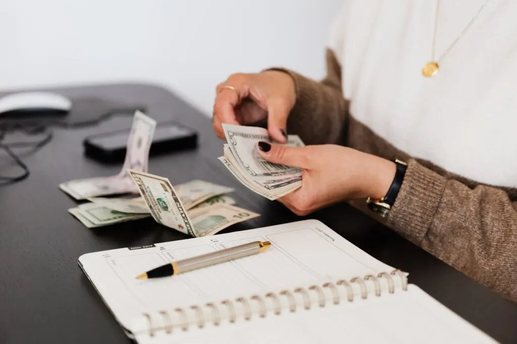 woman counting money (financial goals)