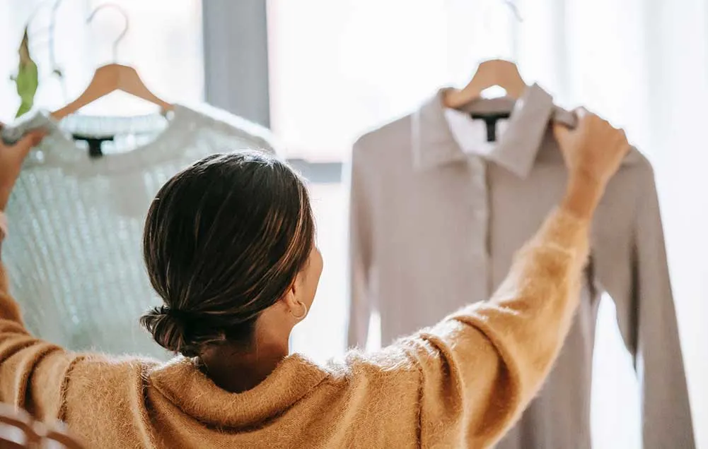 woman picking a shirt from wardrobe