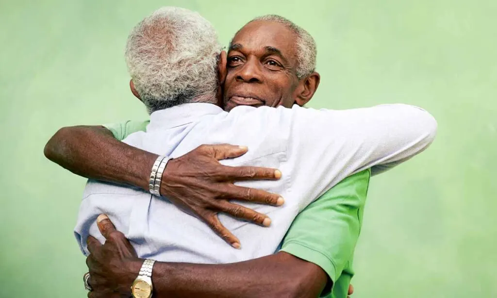 two african-american men hugging 