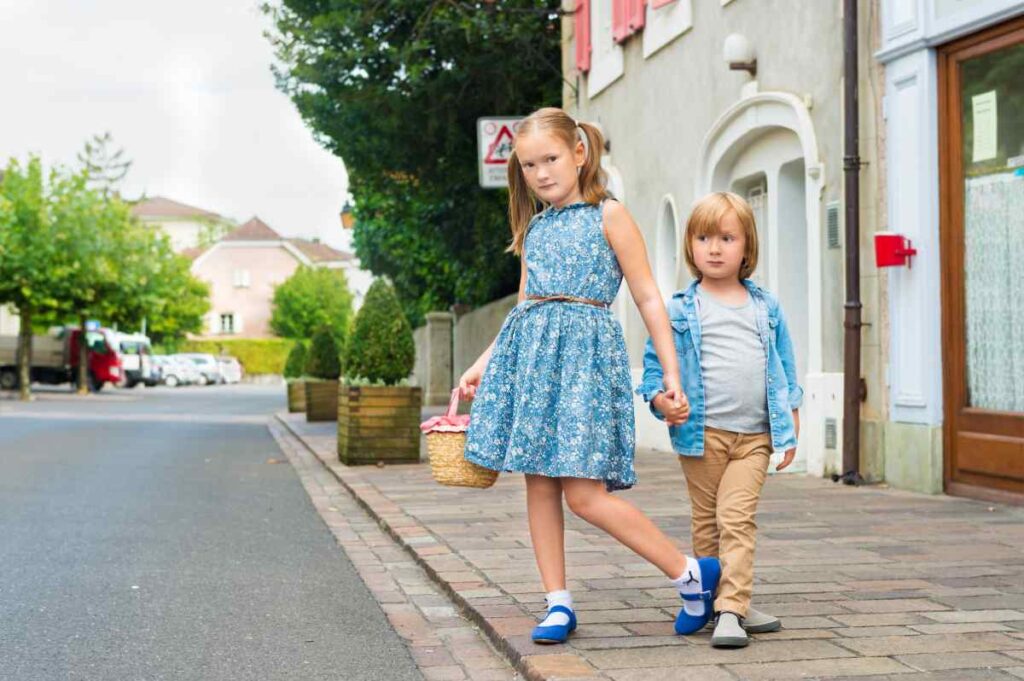 2 kids with blue tops in the street