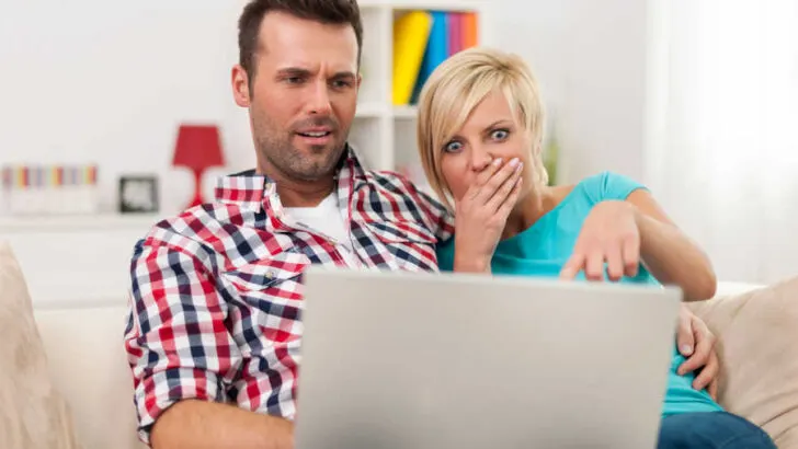 couple on the edge reading on the computer