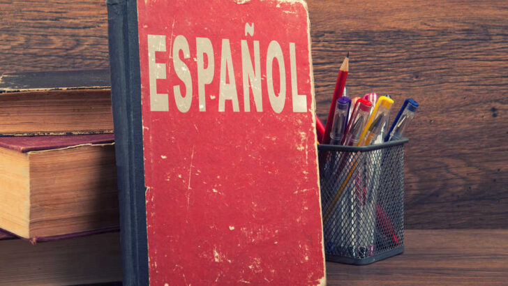 espanol written on a book with a red cover on a wooden table