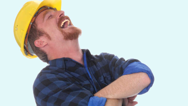 laughing builder with yellow hat on blue background
