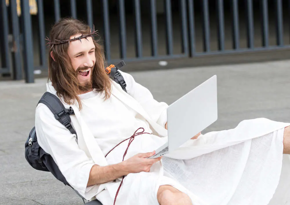 laughing jesus looking at a computer for jokes