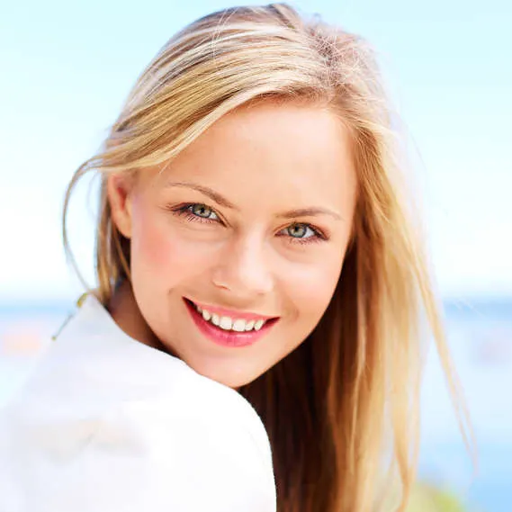 lifestyle image of a blonde woman by the beach