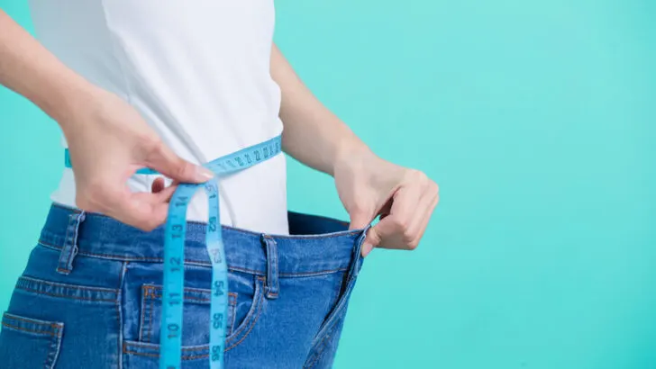 person measuring their waist