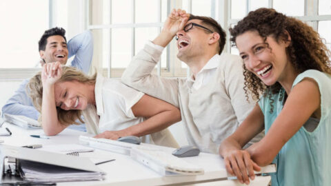 Casual business team laughing during meeting in the office